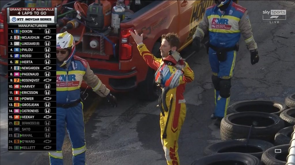 Romian Grosjean in shock as the safety team recovers his stricken car.