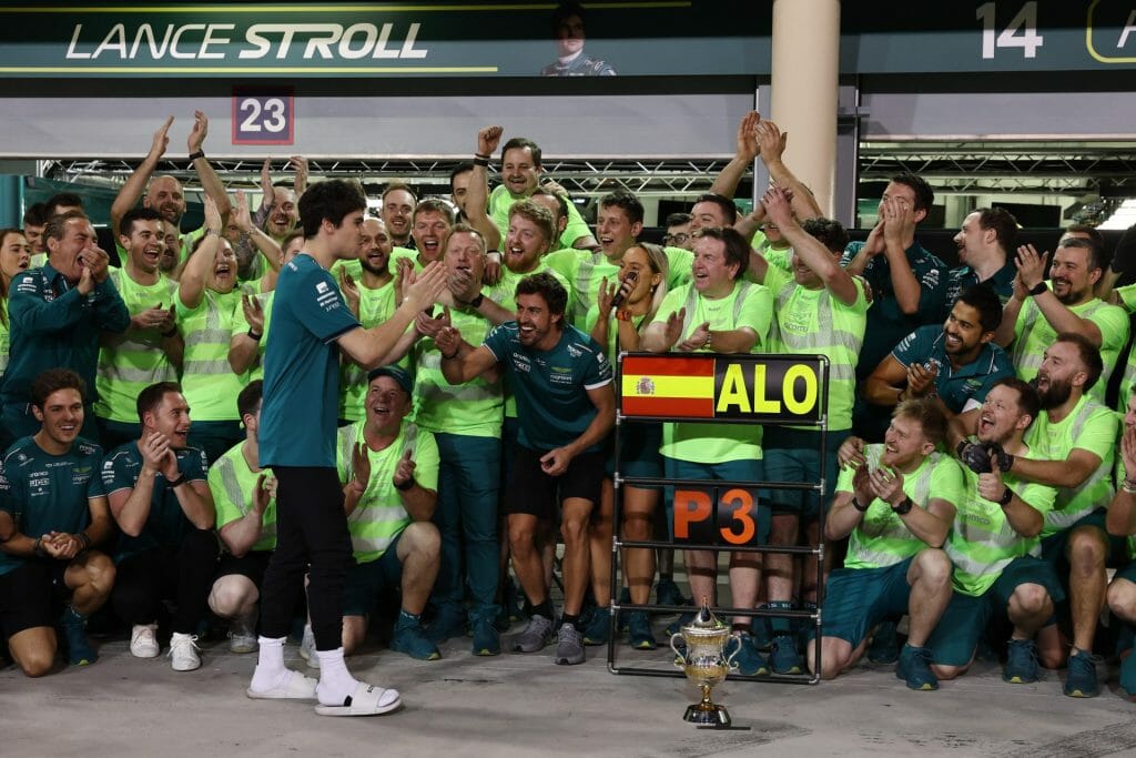 Lance Stroll celebrating with Fernando Alonso and the team after finishing 3rd and 6th in Bahrain.